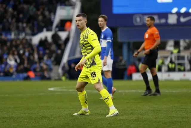 Dan Gore of Rotherham United wearing a yellow kit and number 18 during a football match