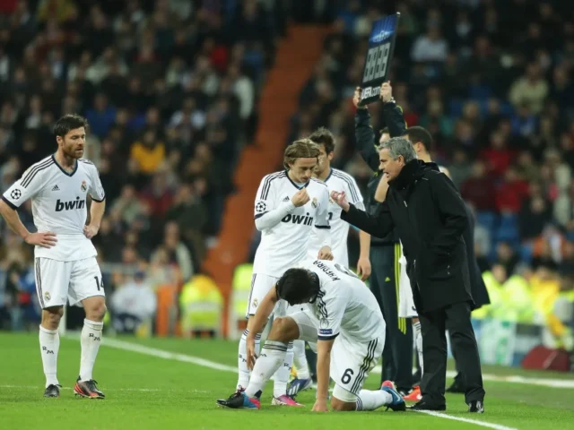 Jose Mourinho gesturing to Real Madrid players during a match at the Santiago Bernabeu stadium.