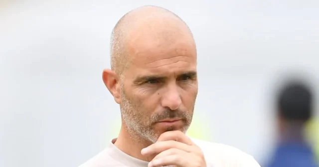 Man City ‘expect Enzo Fernandez deal this week’ with Chelsea Football manager Enzo Maresca holding his chin during a training session held by the head coach while he wears a light-coloured top