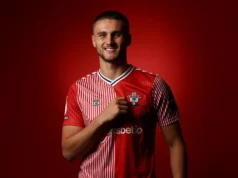Opções de transferência do zagueiro do Manchester United Taylor Harwood-Bellis posing in a red and white striped Southampton FC home kit against a red background